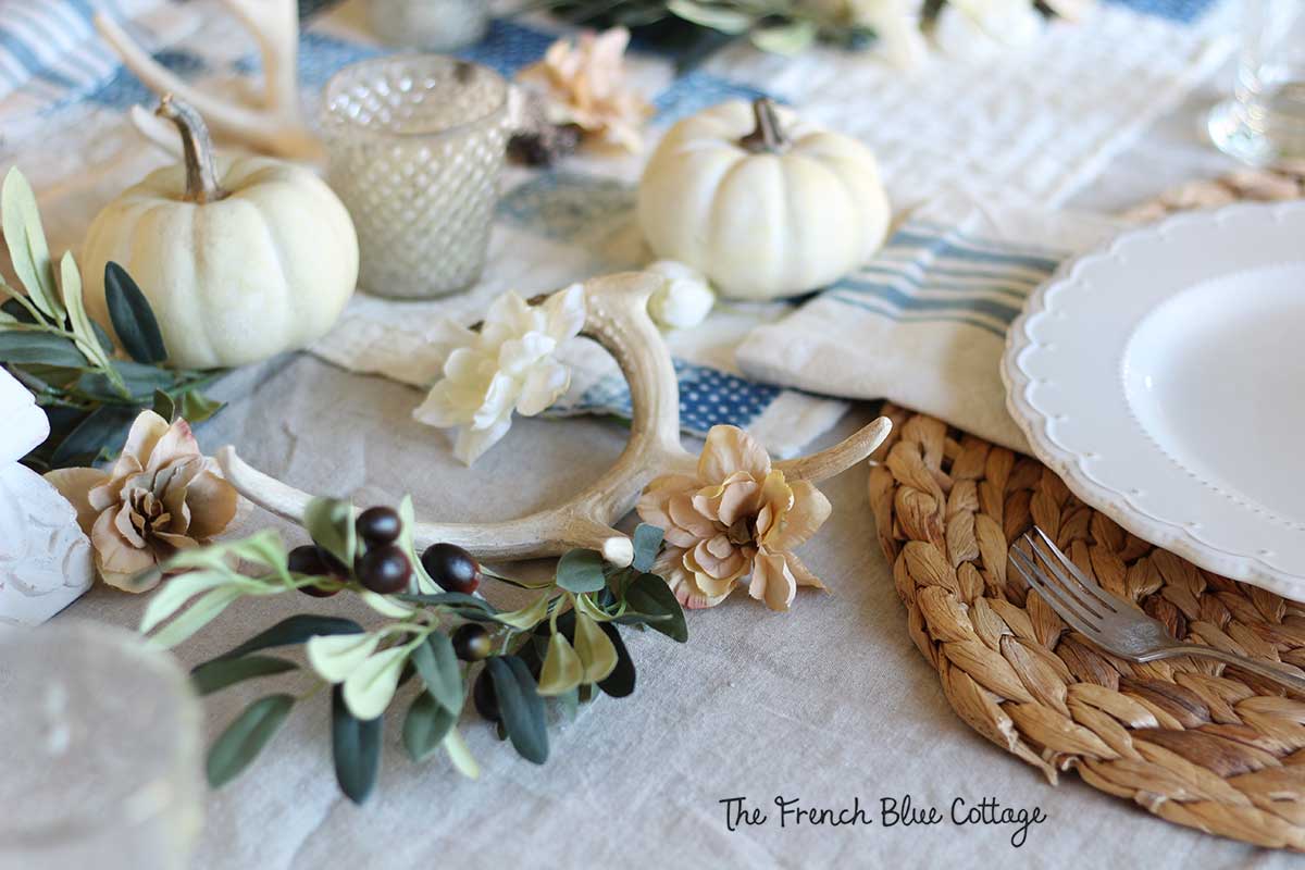neutral fall tablescape with olive branches and deer antlers