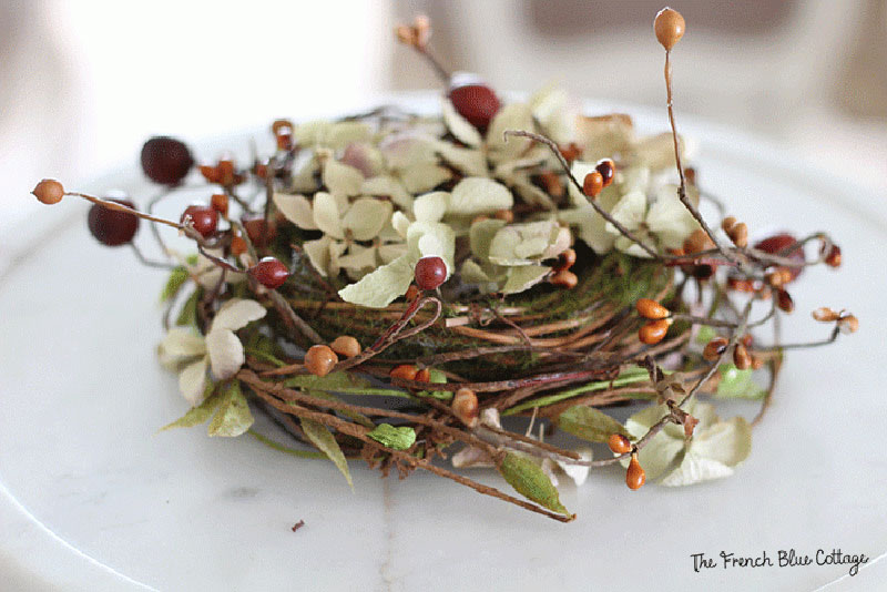 faux bird's nest with fall berries and dried hydrangea petals