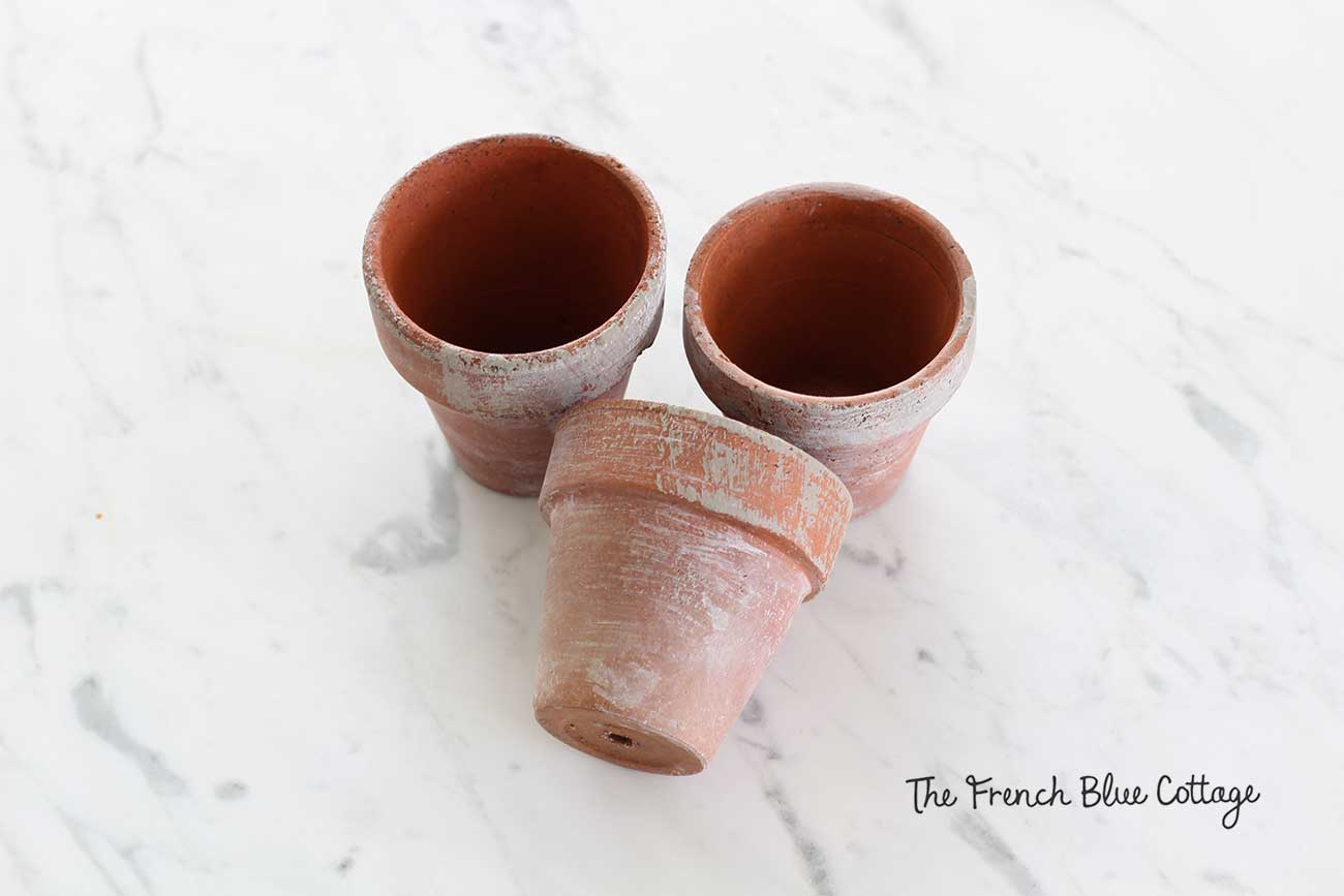 Clay pots dry brushed and whitewashed with gray paint.