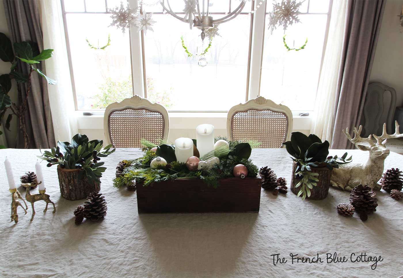 Christmas dining room centerpiece with deer and natural elements.