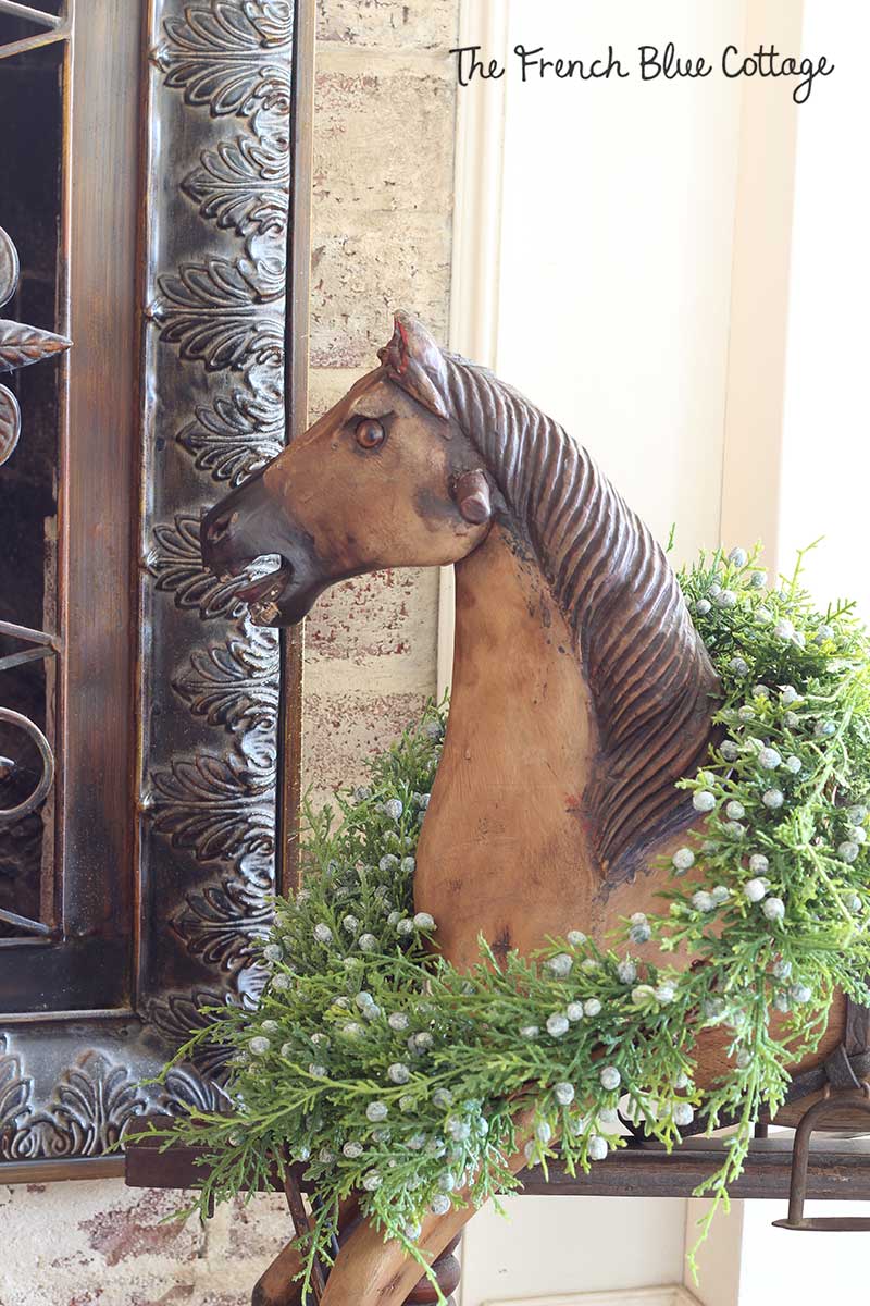 Wood rocking horse with a cedar wreath for Christmas.