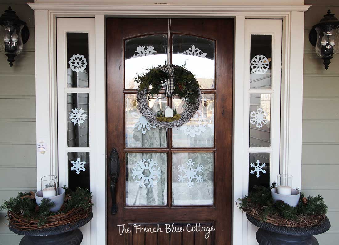 Front door and sidelights with paper snowflakes.