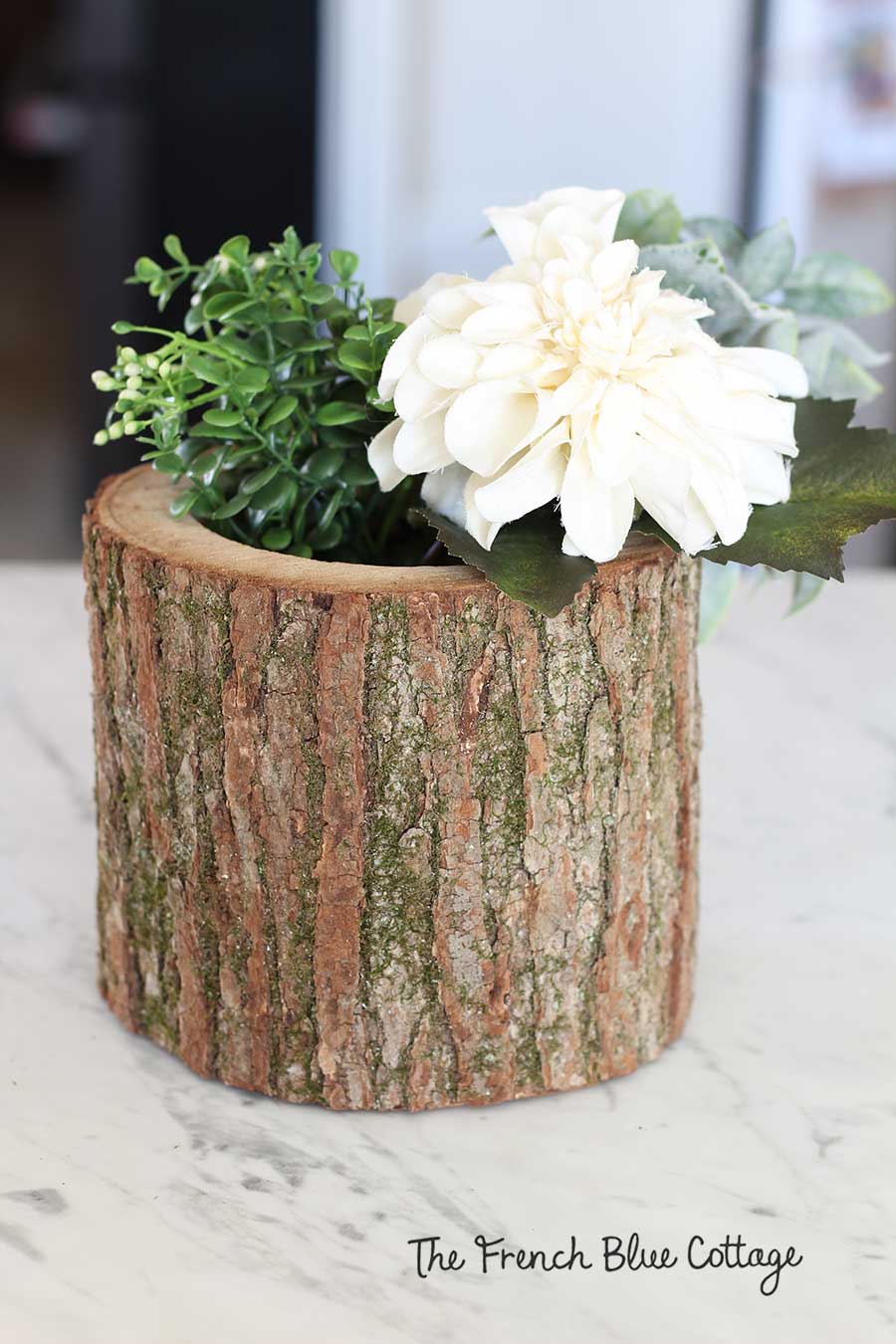 Ivory flowers and leaves in wood log vase.