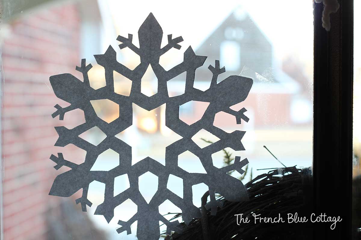 Paper snowflake cut out on window.