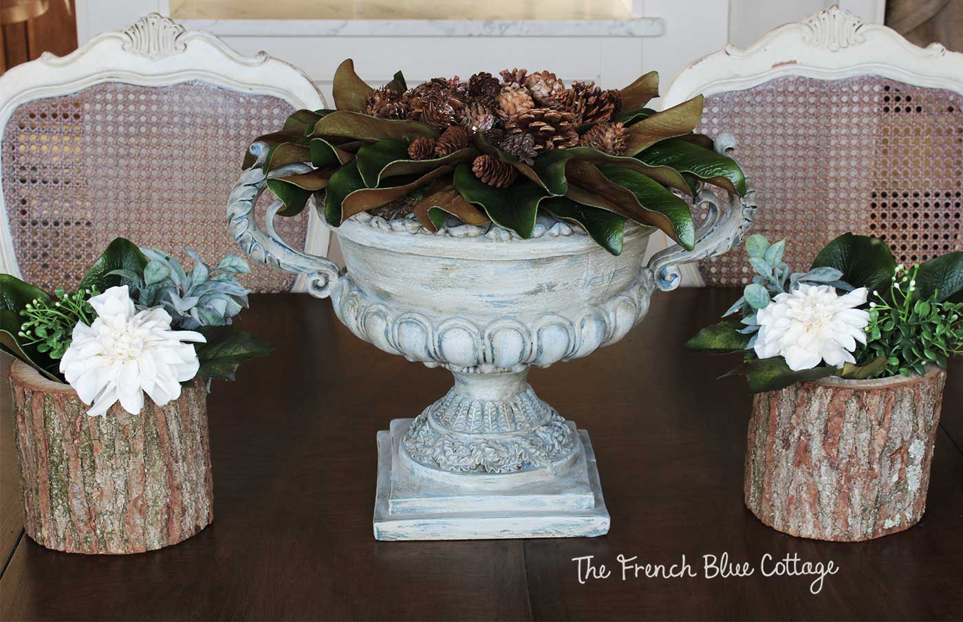 Simple winter table with magnolia, pinecones, and flowers.
