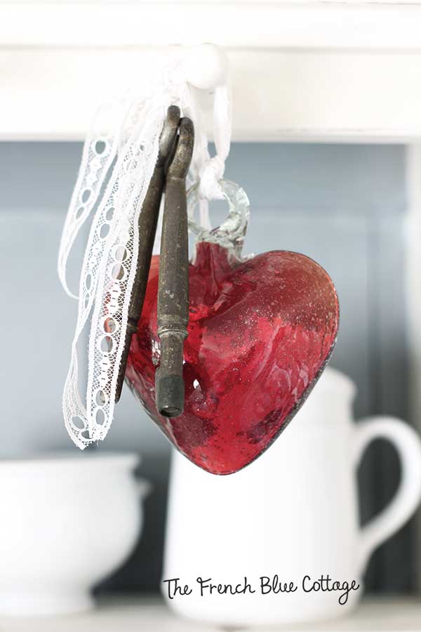 Blown glass heart with keys and lace.