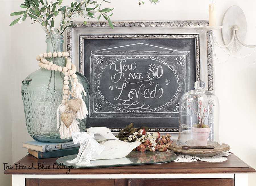 Valentine's chalkboard vignette with flowers and cloche.