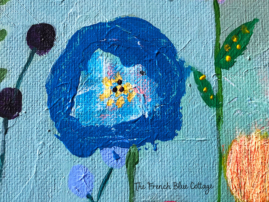 Blue flower with layered paint underneath and lots of texture.