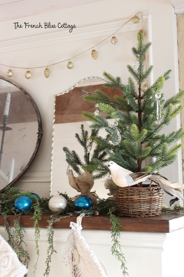 A "woodland glam" mantel with small trees and crystals.