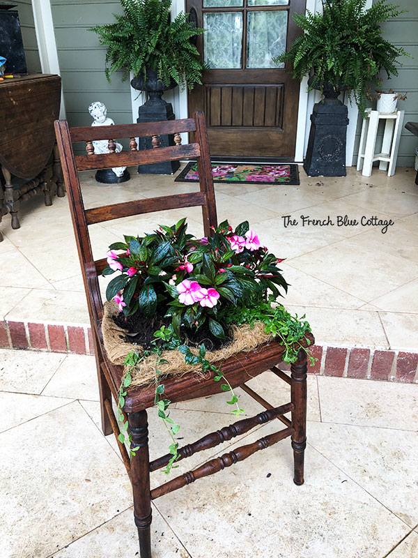wood chair with flowers planted in the seat