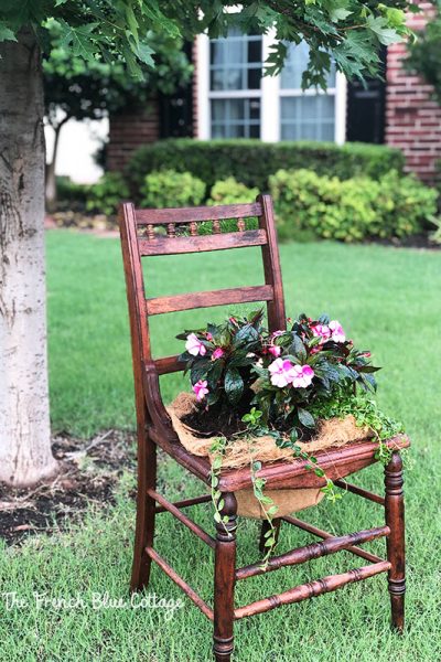 wood chair with flowers planted in seat