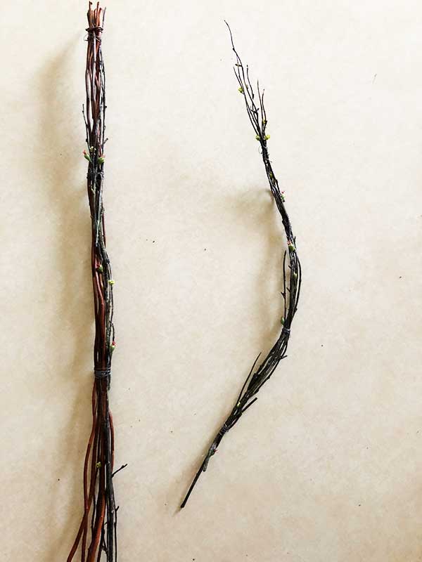 two sets of twigs bunched together to start forming a letter 