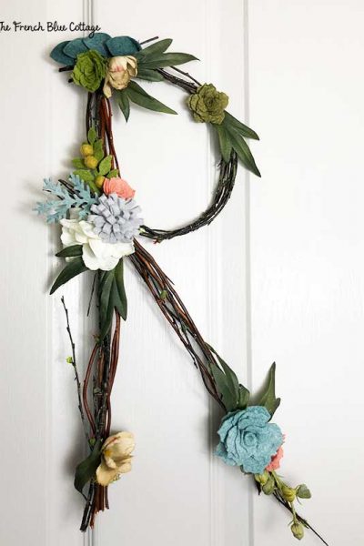 twig letter initial with felt flowers hanging on door