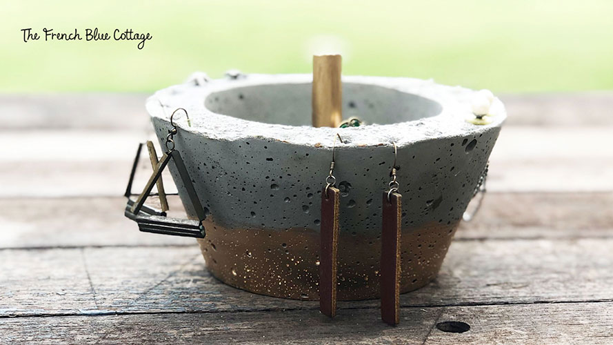 gilded concrete jewelry bowl with earrings hanging on outside