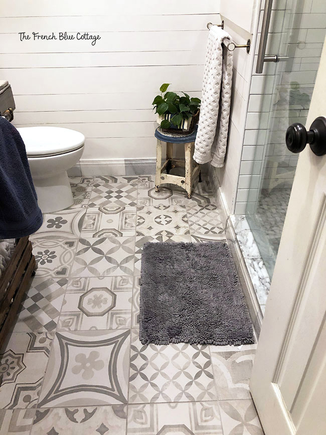 patchwork tiles in gray and white on bathroom floor