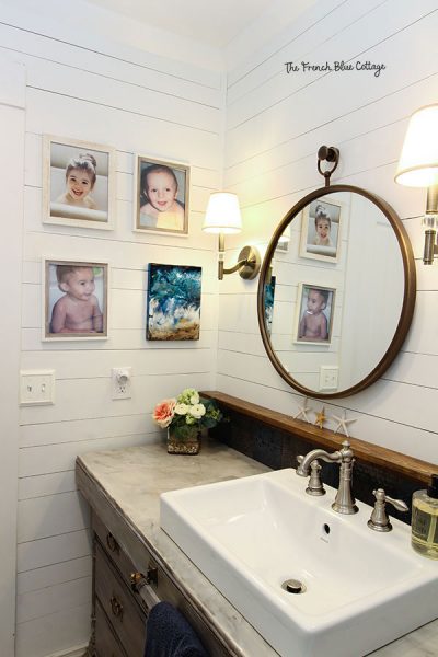 coastal farmhouse bathroom with photos of children and circle mirror