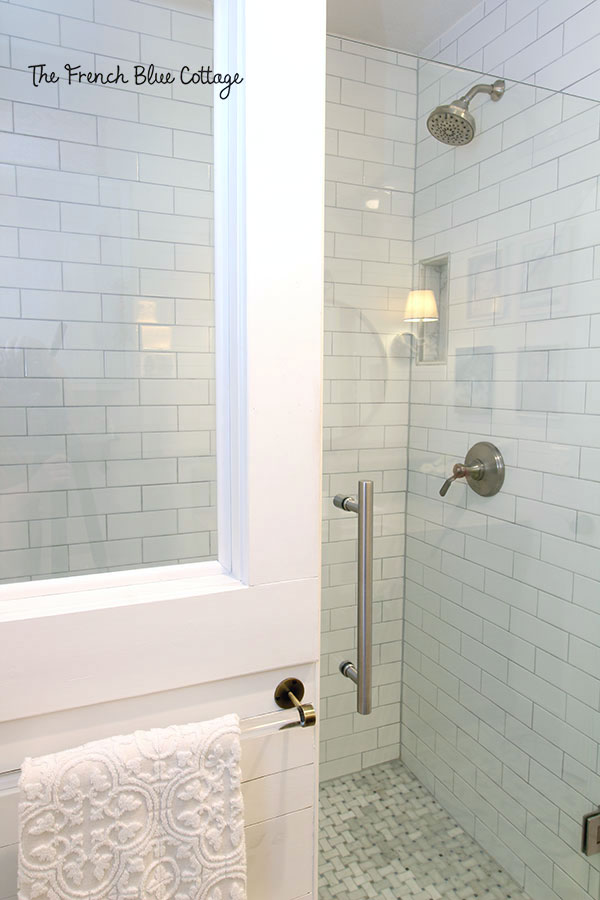 glass shower door with a half wall with a tempered glass window