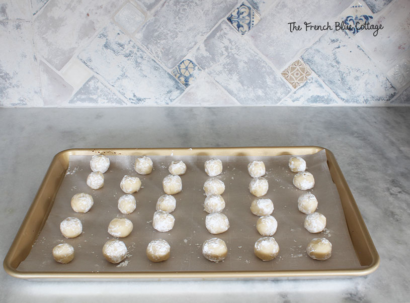 thumbprint cookie balls on a baking sheet