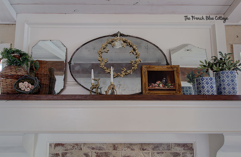 winter mantel with a trio of mirrors, basket jars, and an oil painting