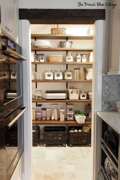 kitchen pantry under the stairs with open shelves and beadboard