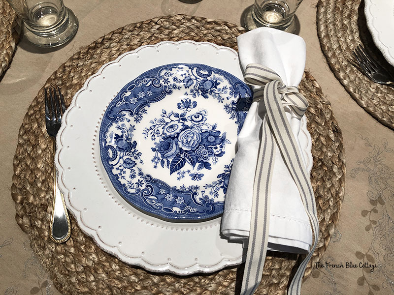 blue and white plate with seagrass placemat and striped ribbon napkin ring with round table ideas