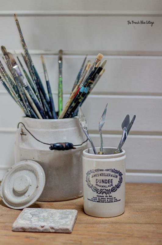 craft room makeover with vintage crocks holding paintbrushes