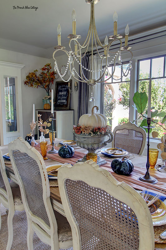 a table set for fall with a view through the large windows into the outdoors
