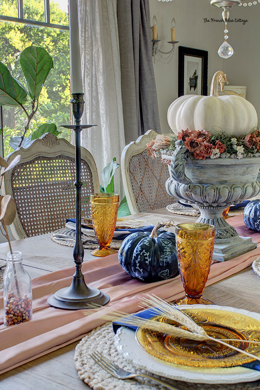 fall tablescape with amber glassware and two sprigs of wheat as plate decorations